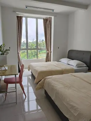 a bedroom with two beds and a desk and a window at Almira Homestay in Brinchang