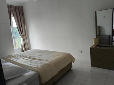 a bedroom with a bed and a dresser and a mirror at Almira Homestay in Brinchang