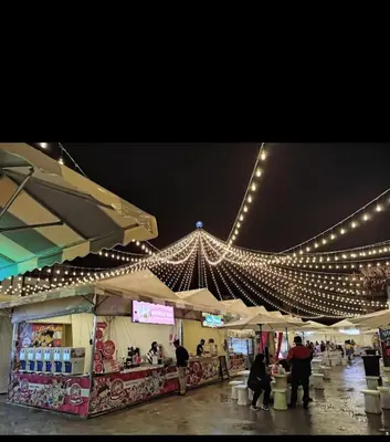 a market with lights and people standing around a store at Almira Homestay in Brinchang