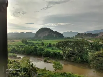a river in a field with mountains in the background at Oasis Condominiums Ipoh in Ipoh
