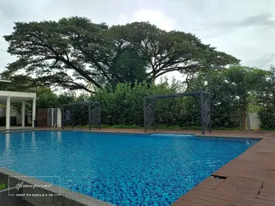 a large blue swimming pool with trees in the background at Oasis Condominiums Ipoh in Ipoh