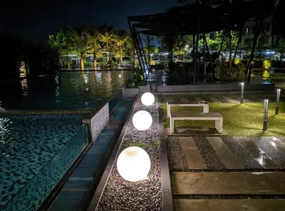 a park with a bench and lights at night at Oasis Condominiums Ipoh in Ipoh