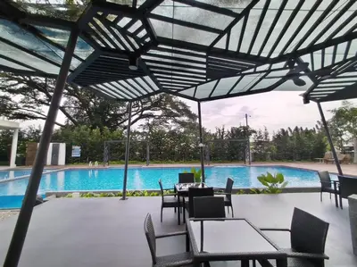 a patio with tables and chairs in front of a pool at Oasis Condominiums Ipoh in Ipoh