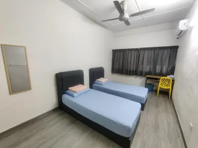 two beds in a room with a table and a window at CLP perai homestay near Sri Muniswarar temple in Perai