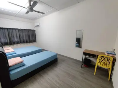 a room with two beds and a desk in it at CLP perai homestay near Sri Muniswarar temple in Perai
