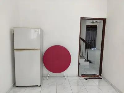 a room with a refrigerator and a red chair at CLP perai homestay near Sri Muniswarar temple in Perai