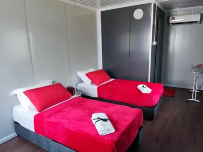 two beds in a room with red and white sheets at al Hajari Inn - For Islam Only - Kg Banggol Batu Lenggong in Kampong Banggol Belimbing