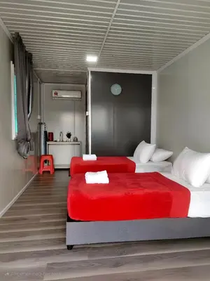 a bedroom with two beds with red sheets at al Hajari Inn - For Islam Only - Kg Banggol Batu Lenggong in Kampong Banggol Belimbing