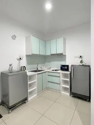a kitchen with white cabinets and a sink and a refrigerator at Mansion One l 7pax 2R1B l Seaview l Gleneagles l by PerfectSweetHome in George Town