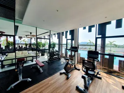 a gym with cardio equipment in a building with windows at Meritus Residence 4min to Penang Bridge in Perai