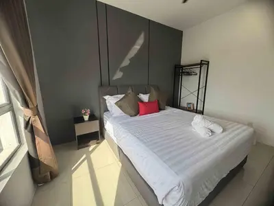 a bedroom with a large white bed with red pillows at Manhattan Ipoh Family Suites By Inn Lux in Ipoh