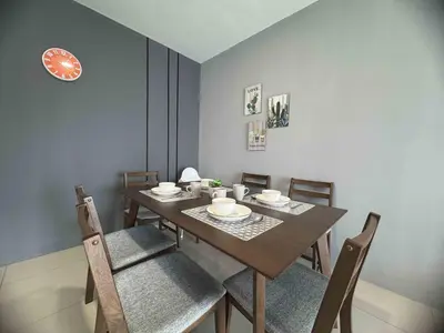 a dining room with a table and chairs and a clock at Manhattan Ipoh Family Suites By Inn Lux in Ipoh