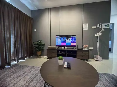 a living room with a table and a television at Manhattan Ipoh Family Suites By Inn Lux in Ipoh