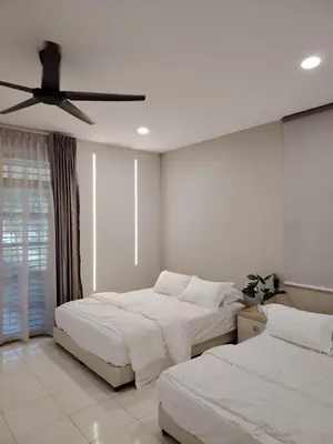 a bedroom with two beds and a ceiling fan at Relax Guest House Bakap Indah in Kampong Gurun