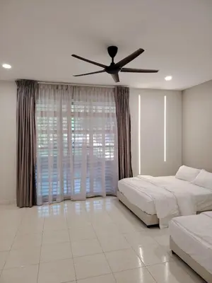 a bedroom with two beds and a ceiling fan at Relax Guest House Bakap Indah in Kampong Gurun