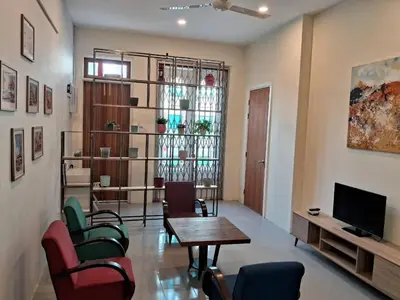 a living room with a table and chairs and a television at Georgetown vintage garden 5pax 2BR Homestay in George Town