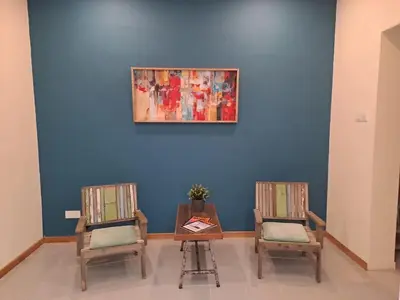 two chairs and a table with a painting on a blue wall at Georgetown vintage garden 5pax 2BR Homestay in George Town