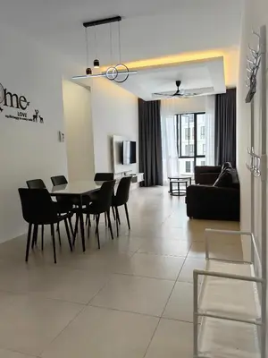 a dining room and living room with a table and chairs at The Glen Apartment Kuching in Gua Sai