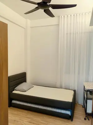 a bedroom with a bed with a ceiling fan at The Glen Apartment Kuching in Gua Sai