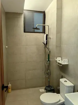 a small bathroom with a toilet and a mirror at The Glen Apartment Kuching in Gua Sai