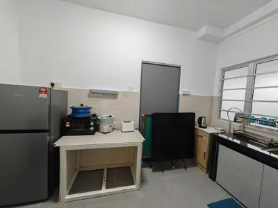 a kitchen with a refrigerator and a table in it at W907WarmStay at EmeraldAvenueBrinchang in Brinchang
