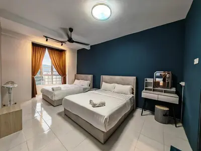 a bedroom with two beds and a blue wall at W907WarmStay at EmeraldAvenueBrinchang in Brinchang
