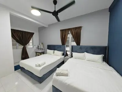 a bedroom with two beds and a blue wall at W907WarmStay at EmeraldAvenueBrinchang in Brinchang