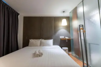 a bedroom with a bed with two towels on it at T+ Hotel Butterworth in Butterworth