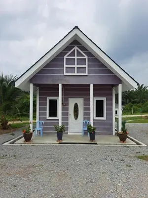 a purple cottage with two chairs and a door at Teratak Sumayyah 1 - For Islam Only - Pondok Lenggong in Kampong Banggol Belimbing