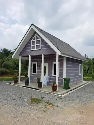 a small purple house with two chairs and potted plants at Teratak Sumayyah 1 - For Islam Only - Pondok Lenggong in Kampong Banggol Belimbing