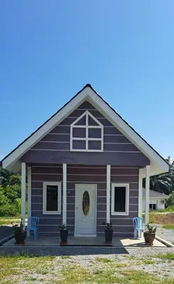 a purple house with two chairs in front of it at Teratak Sumayyah 1 - For Islam Only - Pondok Lenggong in Kampong Banggol Belimbing