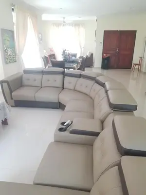 a living room with a sectional couch and a table at Kulim LakeView Homestay at Golf Resort in Kulim