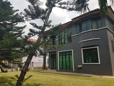 a house with green windows and a tree at Kulim LakeView Homestay at Golf Resort in Kulim