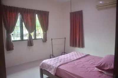 a bedroom with a bed and two windows at Kulim LakeView Homestay at Golf Resort in Kulim