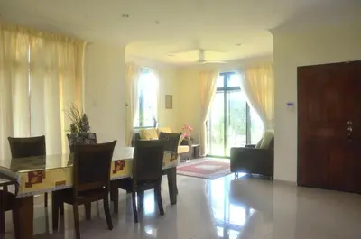 a living room with a dining room table and chairs at Kulim LakeView Homestay at Golf Resort in Kulim