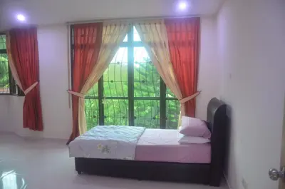 a bedroom with a bed and a window with red curtains at Kulim LakeView Homestay at Golf Resort in Kulim