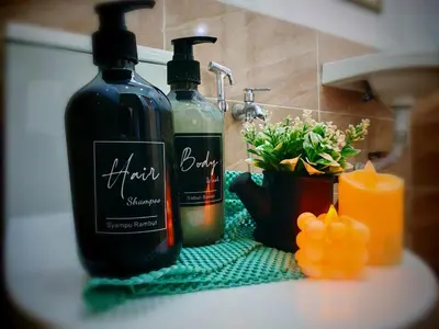 two bottles of wine sitting on a counter next to a candle at Ipoh Happy Home Boutique Villa by City Home Empire in Ipoh