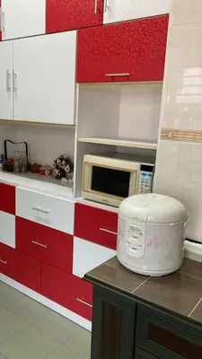 a kitchen with red and white cabinets and a microwave at KKB Gathering Home - Private Room in Shared House in Kuala Kubu Baharu