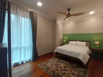 a bedroom with a bed and a green headboard at Hejau Golf Villa in Tanah Rata