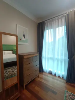 a bedroom with a bed and a mirror and a dresser at Hejau Golf Villa in Tanah Rata