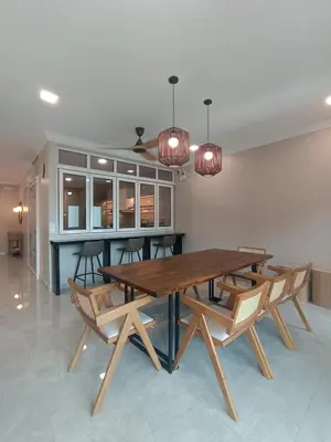 a dining room with a wooden table and chairs at Hejau Golf Villa in Tanah Rata