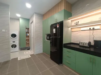 a kitchen with green cabinets and a black refrigerator at Hejau Golf Villa in Tanah Rata