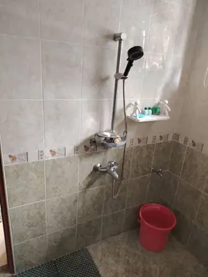 a shower with a red bucket in a bathroom at \u660e\u56fd\u6c11\u5bbf in Gua Sai