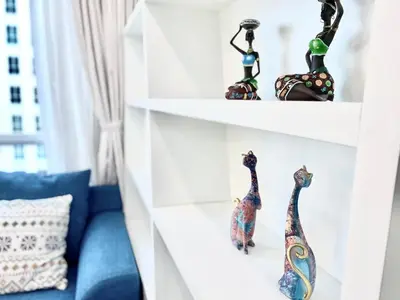 a room with shelves with figurines on them at Straits Garden Suites #Pool with view #Seaview and bridge view #Georgetown #3pax #2BR2bath #1Queen 1Single #Quality well maintained #Private host in George Town
