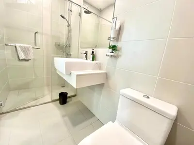 a white bathroom with a sink and a toilet at Straits Garden Suites #Pool with view #Seaview and bridge view #Georgetown #3pax #2BR2bath #1Queen 1Single #Quality well maintained #Private host in George Town