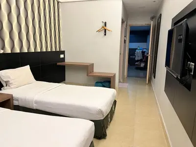 a hotel room with two beds and a tv at Dancenter Near Shell Jalan Iskandar Shah, Orchard in Kampong Tebing Rabak
