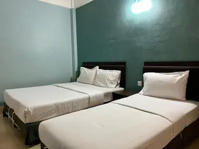 two beds in a hotel room with white sheets at Dancenter Near Shell Jalan Iskandar Shah, Orchard in Kampong Tebing Rabak