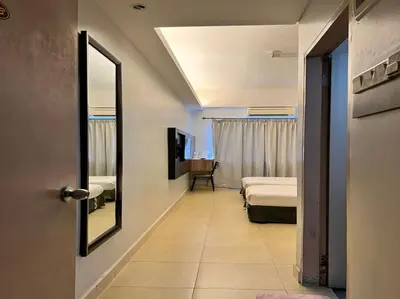 a hallway of a hotel room with two beds and a mirror at Dancenter Near Shell Jalan Iskandar Shah, Orchard in Kampong Tebing Rabak