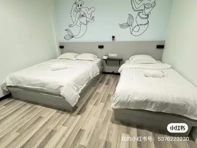 two beds in a small room with wood floors at \u5343\u5c9b\u7f8e\u4eba\u9c7c\u9152\u5e97 in Gua Sai