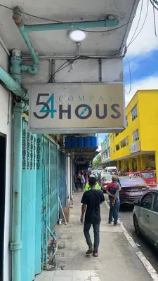 a man walking down a sidewalk under a store sign at \u5343\u5c9b\u7f8e\u4eba\u9c7c\u9152\u5e97 in Gua Sai